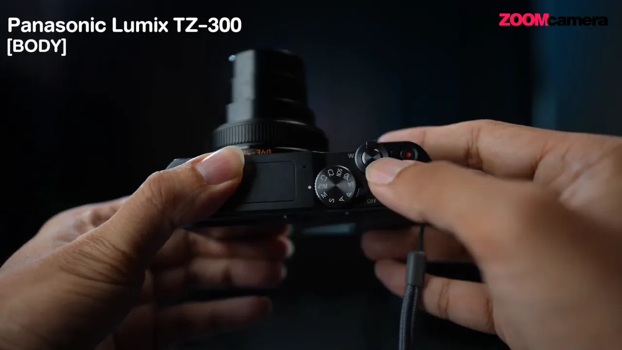 มือกำลังปรับโหมดบน Panasonic Lumix TZ-300 ด้วยแป้นหมุน